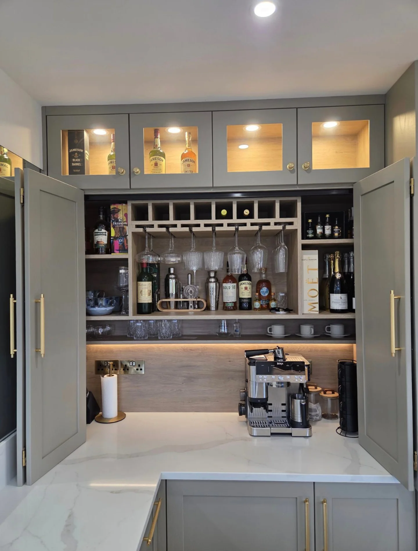 Open grey fitted bar cabinet with internal storage and display shelving.