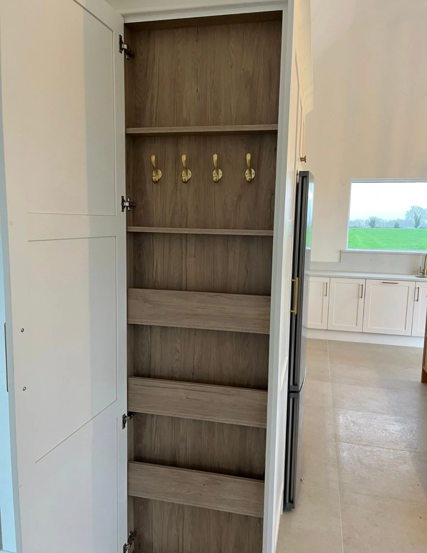 Hidden fitted coat storage with flush cabinetry and internal hanging space.