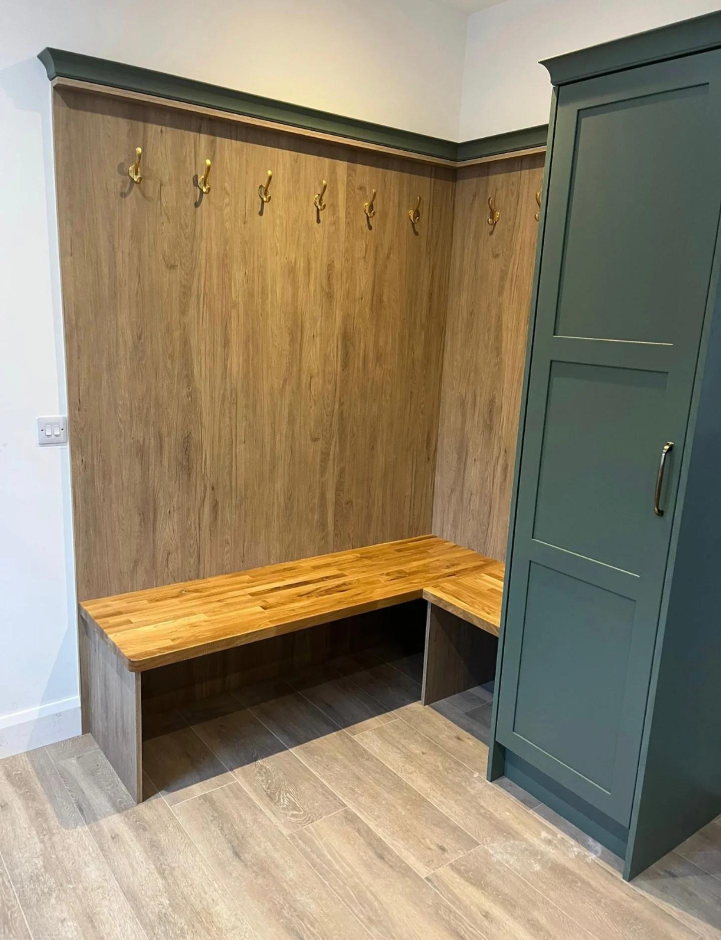 Oak boot room bench with hooks, open shelving and fitted shoe storage.