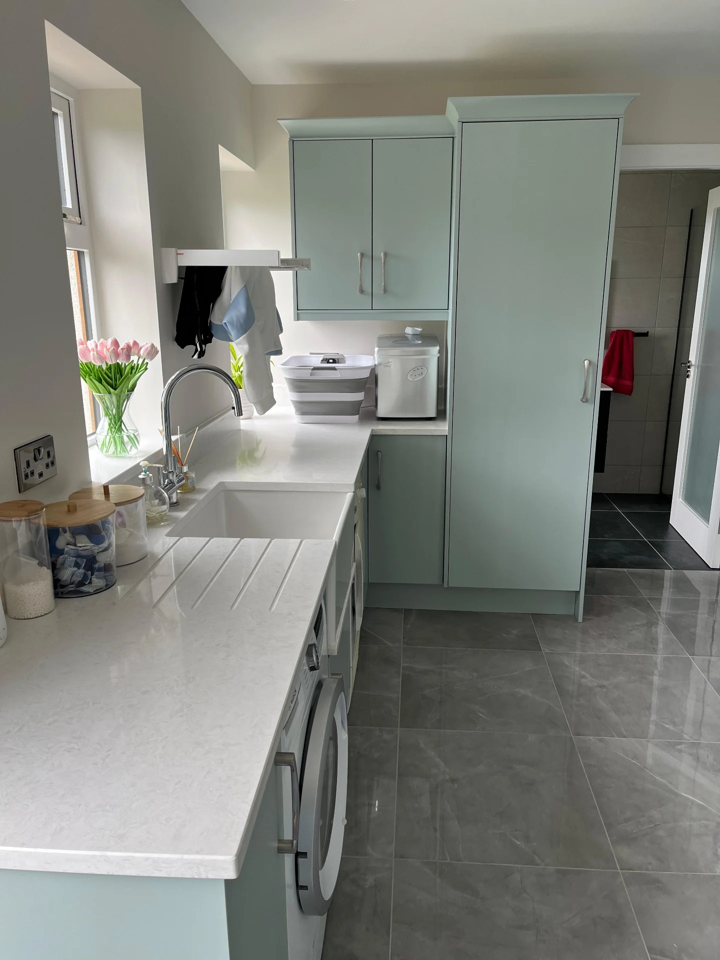 Sage utility room with fitted sink, drawers and made-to-measure storage.