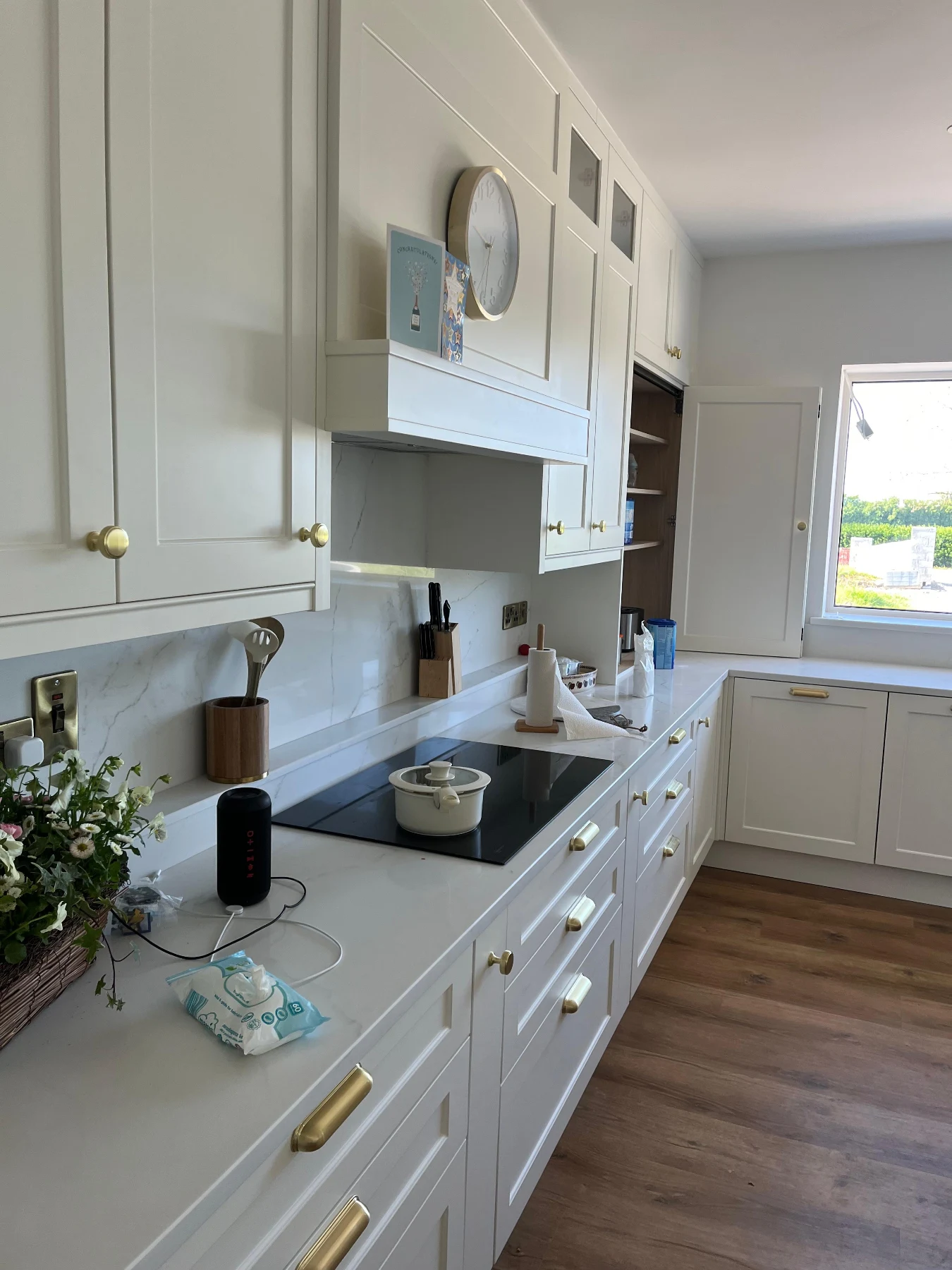 Cream shaker cabinetry detail with warm brass handles and stone worktop.